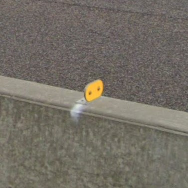 Yellow oval on concrete barrier