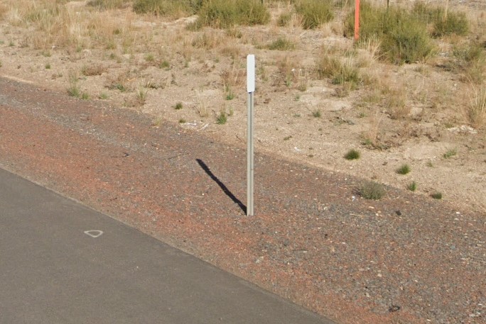 White paddle bollard and red gravel strip